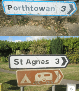 A deteriorated road sign needing replacement with a new bilingual sign
